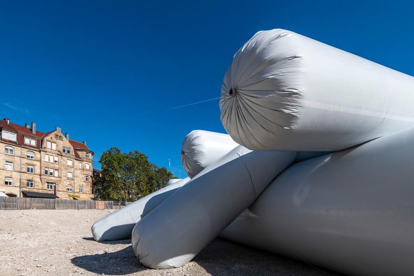 Das Bild zeigt das aufblasbare Kunstwerk aus der Vogelperspektive, eingebettet in das städtische Umfeld mit dicht stehenden Häusern, Straßen und Grünflächen.