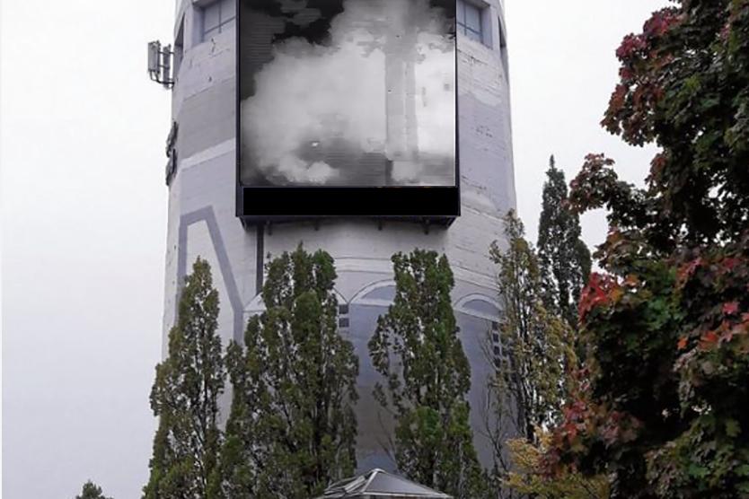 Das Bild zeigt den Robert-Bosch-Turm, an dem sich eine große Bildschirmfläche befindet. Auf dieser sind Rauchwolken einer Nebelmaschine zu sehen.