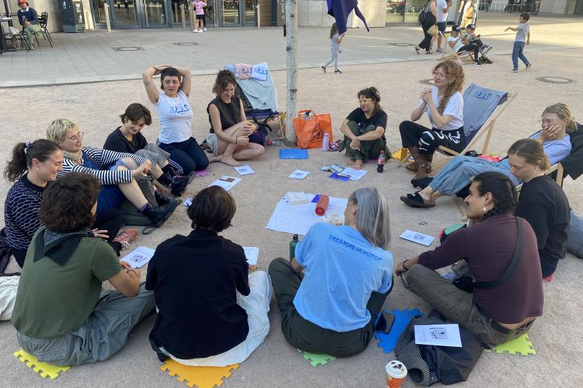 Ein Kreis aus Menschen im öffentlichen Raum.